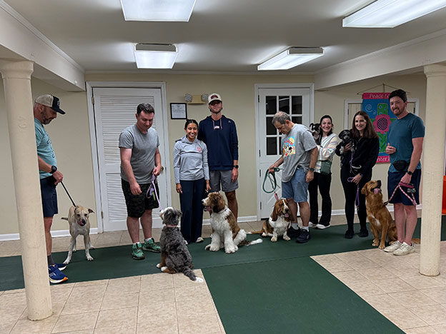 Proud dog owners with their pets at a training class graduation ceremony