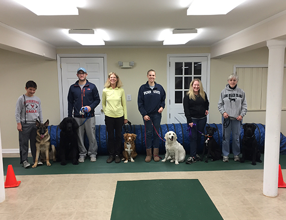 A group of proud dog owners and their pets posing at Canine Good Citizen Certification Ceremony