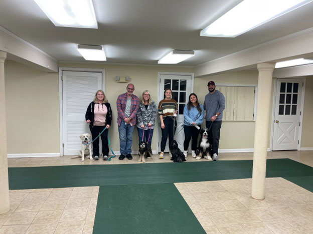 Proud dog owners with their pets at a training class graduation ceremony