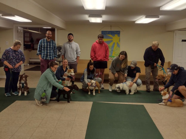 Proud dog owners with their pets at a training class graduation ceremony
