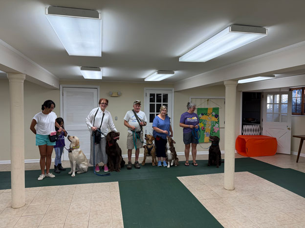 Proud dog owners with their pets at a training class graduation ceremony
