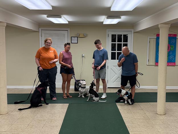 Proud dog owners with their pets at a training class graduation ceremony